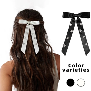 Elegant satin bow hair clip with crystal stars, featuring black and white color options