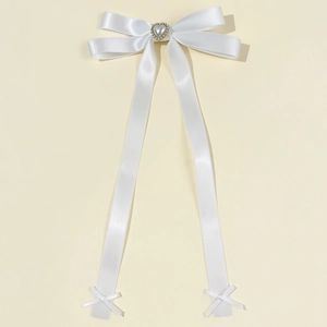 Detail der weißen Satin-Ballettschleife mit Perlenherz und eleganten langen Bandstreifen