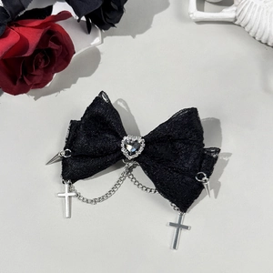 Detail of gothic lace bow hair clip featuring heart gem, silver crosses and metallic spikes