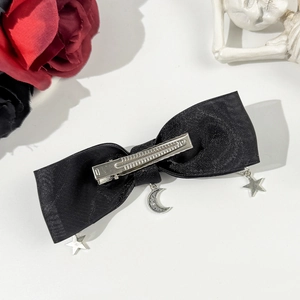 Barrette nœud noir gothique avec pendentifs étoile et lune, vue sous un angle de 45 degrés