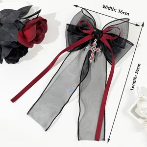 Detail of gothic hair clip with black lace, red ribbon, silver cross and dark rose