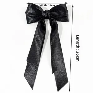 Detailed view of black satin bow hair clip with ribbons measuring 14cm wide and 26cm long