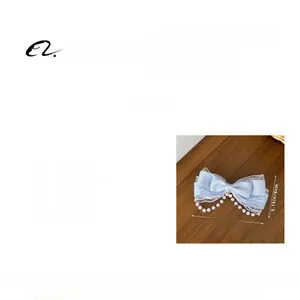 Detailed view of light blue Lolita hair clip with lace, pearls, and tassel chain