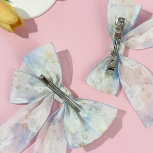 Lot de barrettes à cheveux nuds en mousseline fleurie bleue et violette sur fond rose