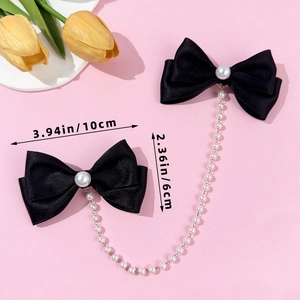Detail of black silk bow hair clips with faux pearl tassels and central pearl accent