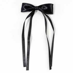 Detailed view of the elegant black satin bow hair clip with long flowing ribbons