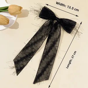Detail view of black chiffon bow hair clip with sequins showing 13.5cm width and 27cm length