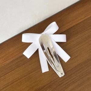 Barrette à cheveux avec nœud en ruban blanc de style ballet sur un support en bois