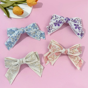Ethnic floral embroidered bow hair clip set in four vintage colors on pink background