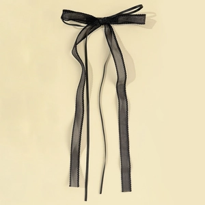 Detail of black mesh ribbon hair clip with delicate scalloped edges and elegant bow design