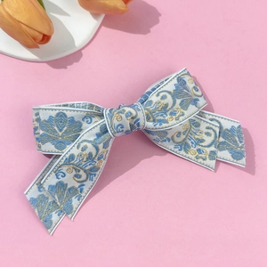 Elegant floral embroidery bow hair clip with blue Chinese patterns on a satin fabric base