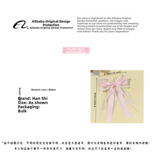 Dettaglio del fermaglio per capelli con fiocco in pizzo rosa e nastri lunghi eleganti