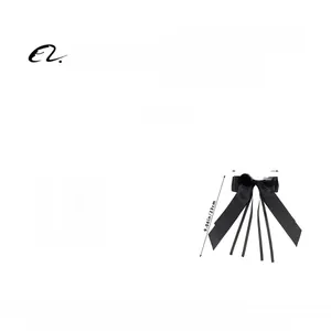 Détail d'une pince à cheveux nœud en ruban noir avec strass cœur et longs rubans