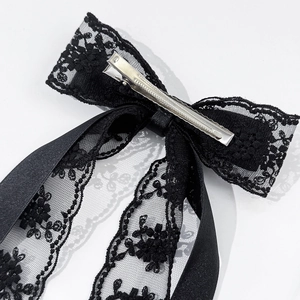 Détail de la pince à cheveux noeud en dentelle noire avec fermoir crocodile argent