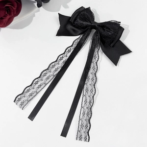 Detail of black lace bow hair clip with satin ribbons and rose decorative elements