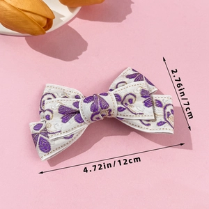 Detailed view of white floral bow hair clip with purple embroidery and size dimensions