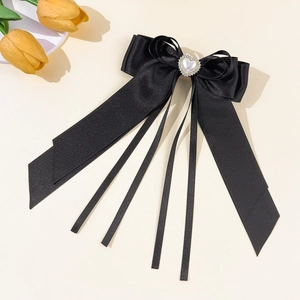 Détail d'un nœud en satin noir avec perle en cœur et longs rubans de soie élégants