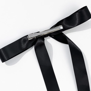Detailed back view of black satin bow hair clip showing the silver metal crocodile clip