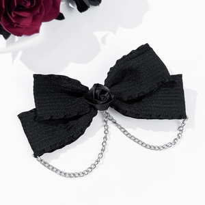 Détail du nœud gothique noir avec rose et chaînes métalliques argentées sur blanc