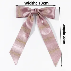 Detail view of purple glitter bow hair clip with gold stripes, width 13cm and length 20cm