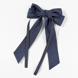 Barrette à nœud en jean avec coutures orange contrastées et longs rubans sur fond blanc
