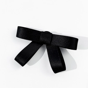Close-up of black satin bow brooch with high-density texture and elegant symmetry