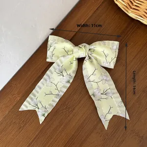 Detailansicht der gelben Blumen-Haarschleife mit Muster, Maße 11 cm breit und 14 cm lang