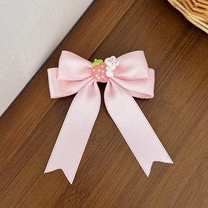 Pince à cheveux noeud en satin rose avec fraise et lapin sur fond de bois sombre