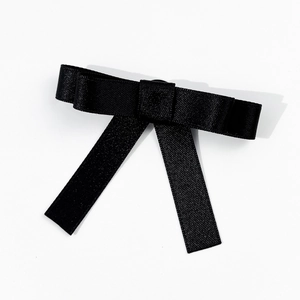 Detail of the elegant black satin ribbon bow with smooth texture and layered design