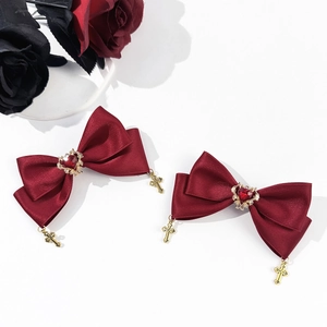 Detail of red satin bow hair clips with heart gems and gold gothic cross pendants