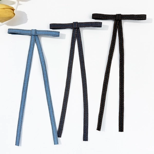 Three-piece denim bow hair clips in light blue, dark blue, and black with yellow stitching