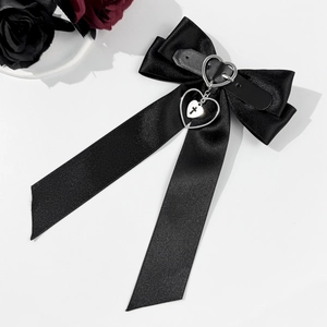 Détail d'un nœud en satin gothique avec boucle de cuir en cœur et pendentif croix en argent