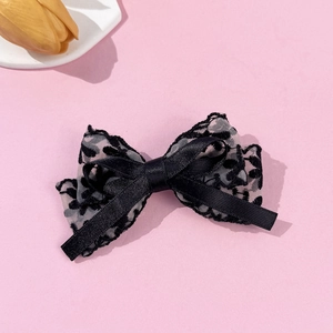 Elegant leopard print lace bow hair clip with black satin on a soft pink background