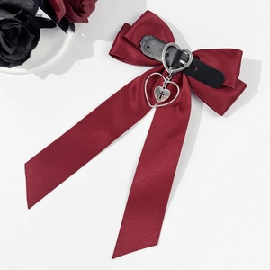 Détail macro du nœud gothique rouge vin avec sangle en cuir et pendentif cœur en argent