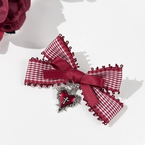 Detail of Gothic bow hair clip with plaid ribbon and silver heart cross pendant