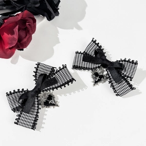 Detail of gothic checkered bow hair clips with heart cross pendant and black lace trim