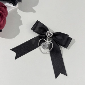 Macro de barrette nœud en satin noir avec pierre cœur et pendentif croix gothique