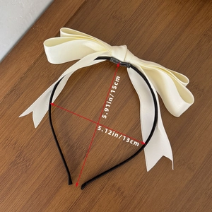 Détail du serre-tête nœud en satin crème montrant les dimensions 15cm x 13cm