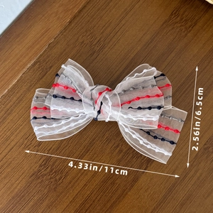 Detailed view of white mesh bow hair clip with colored dots and size measurement scale