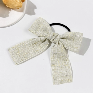 Elastico per capelli in tweed con riflessi dorati e lunghi nastri su fondo bianco