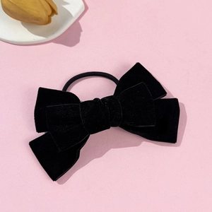 Detail of black velvet bow hair tie with rich fabric texture and high-elastic rubber band
