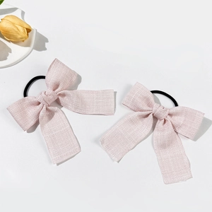 Dettaglio di elastici per capelli con fiocchi rosa in tessuto e texture scintillante