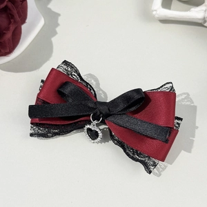 Détail d'une pince à cheveux gothique avec ruban rouge et pendentif cœur en cristal