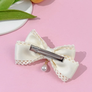 Pinza para el pelo Lolita con lazo de encaje crema y perla sobre fondo rosa