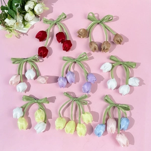 Dettaglio di fermagli per capelli a tulipano in raso colorato con fiocchi rosa