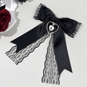 Barrette nœud gothique en dentelle noire avec pendentif cœur et croix sur fond gris