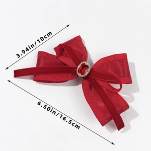 Macro shot of large red satin bow hair clip with oval ruby centerpiece and measurements