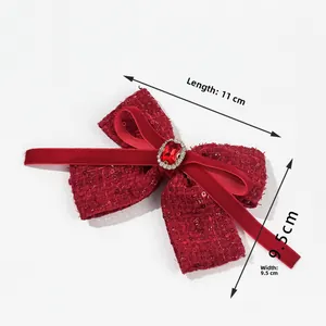 Detail view of red tweed Christmas bow clip with gemstone and 11cm length dimensions