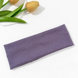 Detalle de diadema de punto morada con textura clara sobre un fondo blanco decorativo