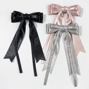 Three elegant satin bow hair clips in black, pink, and silver with long ribbons